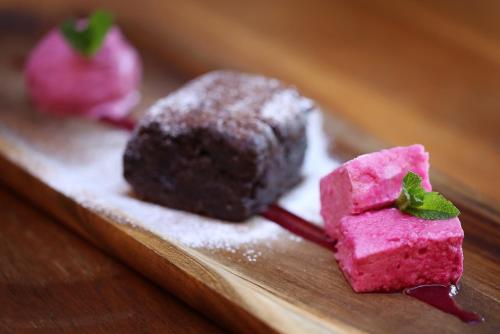 two pieces of pink desserts on a wooden plate at The Museum Inn in Farnham