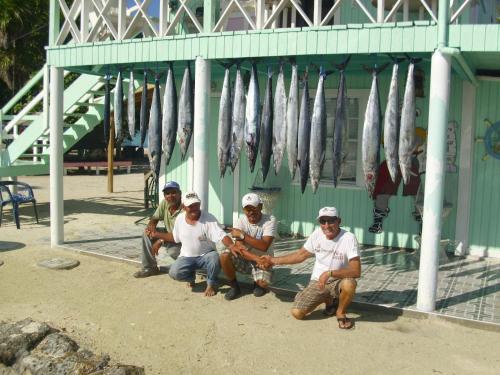 a group of men sitting in front of a building at Graham's Place in Guanaja