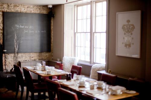 a dining room with tables and chairs and a chalkboard at The Archangel,Restaurant & Bar with Rooms in Frome