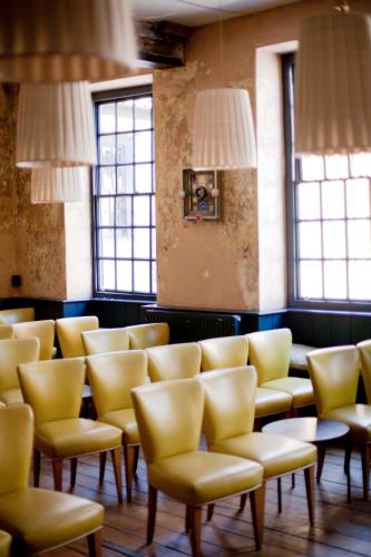 a row of chairs in a room with windows at The Archangel,Restaurant & Bar with Rooms in Frome