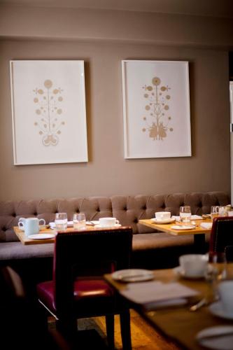 a dining room with two tables and a couch at The Archangel,Restaurant & Bar with Rooms in Frome