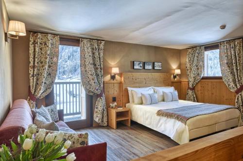 a hotel room with a bed and a balcony at Hotel Sant'Orso - Mountain Lodge & Spa in Cogne