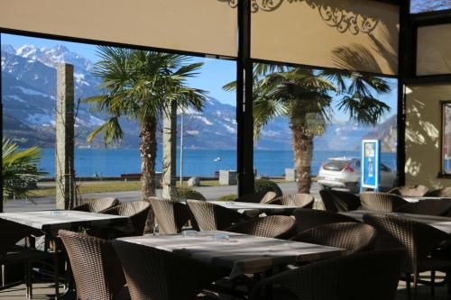 a restaurant with tables and chairs and palm trees at Hotel Seehof Superior in Walenstadt