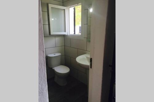 a bathroom with a toilet and a sink and a window at cala serena beach 6 in Cala Serena