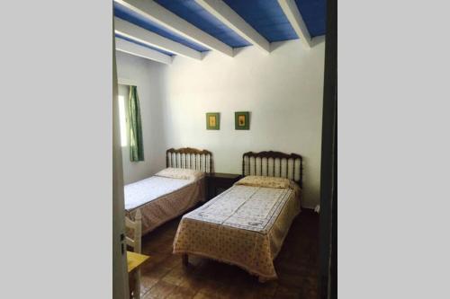 zwei Betten in einem Zimmer mit blauen Decken in der Unterkunft cala serena beach 6 in Cala Serena