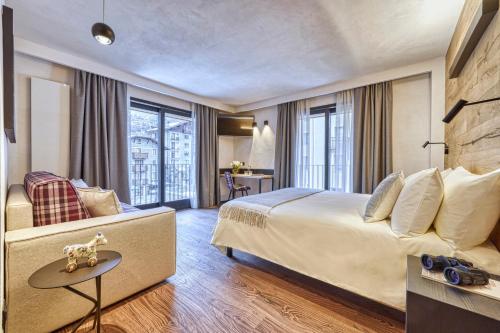 a hotel room with a large bed and a table at Hotel Sant'Orso - Mountain Lodge & Spa in Cogne