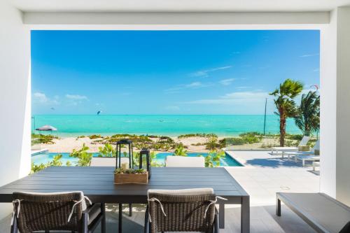 a dining room with a table and a view of the beach at H2O LifeStyle Resort in Long Bay Hills