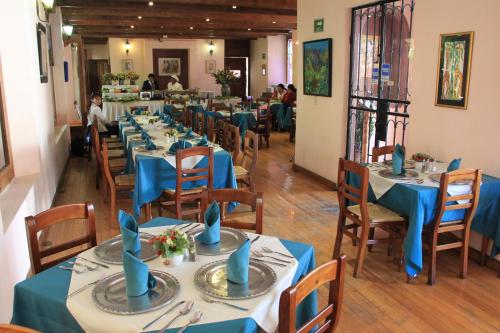 a dining room with blue tables and chairs at Hotel Casa Mexicana in San Cristóbal de Las Casas