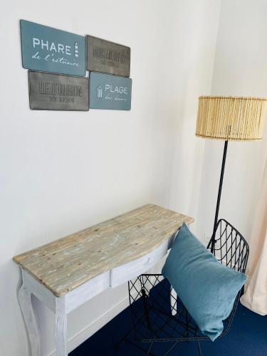 a table with a pillow next to a lamp at Face aux Flots in La Cotinière