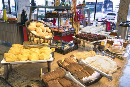a buffet with bread and other food on a table at Hotel Dan Inn Campinas Anhanguera - By Nacional Inn in Campinas