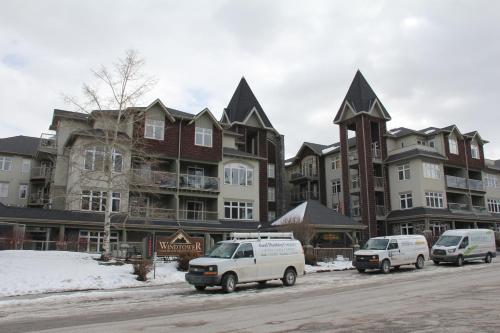 two vans parked in front of a large building at Windtower Lodge - Canmore in Canmore