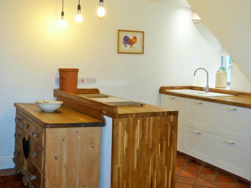 a kitchen with wooden counters and a sink at Roman Cottage - - Hadrian's Wall dark sky outpost. in Newcastle upon Tyne
