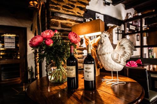 two bottles of wine and a chicken on a table at Auberge Aal Veinen in Vianden