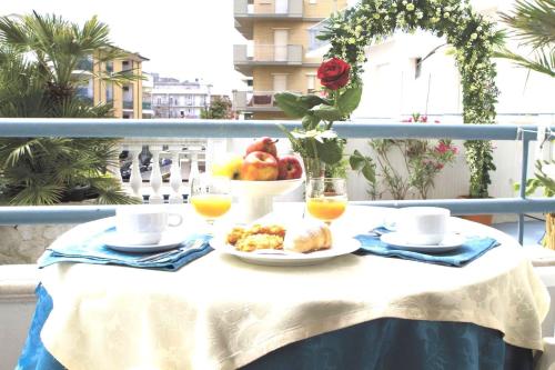 einen Tisch mit einem Teller Essen und einer Schale Obst in der Unterkunft Hotel Vienna in Bellaria-Igea Marina