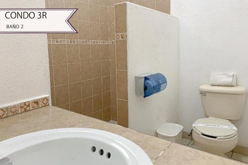 a bathroom with a bath tub and a toilet at Condominios JAROJE in Santa Cruz Huatulco