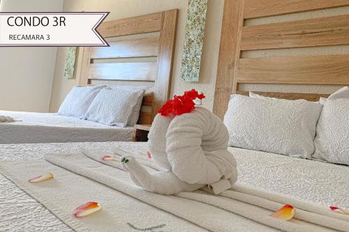 a stuffed animal is sitting on a bed at Condominios JAROJE in Santa Cruz Huatulco