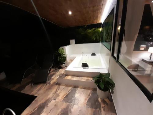 uma casa de banho com um lavatório branco e algumas plantas em Cabaña miramar em Pereira