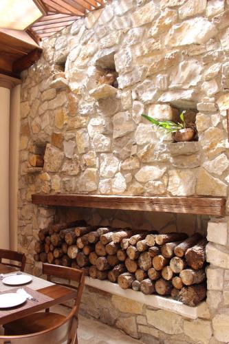 a stone wall with a fireplace with logs on it at La Estancia in San Cristóbal de Las Casas