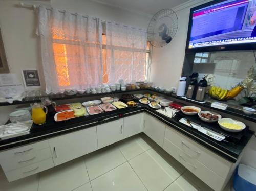 a kitchen counter with a lot of food on it at Hotel Colonial in Pôrto Ferreira