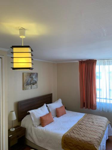 1 dormitorio con cama y lámpara de araña en CentriK Location Apartments Encomenderos 200, en Santiago