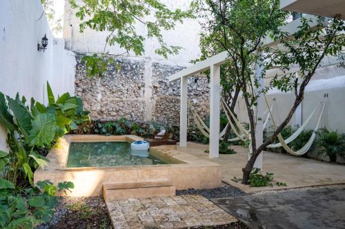 a garden with a hot tub in the middle of a yard at Hotel & Hostal Boutique Casa Garza in Mérida
