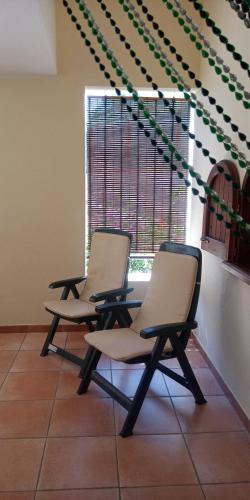 two chairs sitting in a room with a window at Vacanze a Solanas con Clima CUP1863 in Solanas