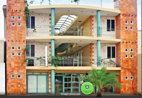 a tall brick building with a balcony and a window at Hotel Santa Maria in Cancún