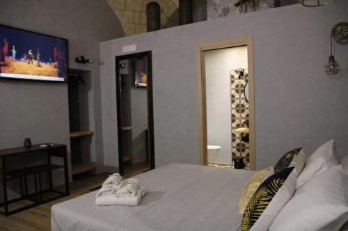 a bedroom with a bed with white towels on it at La Dimora del Principe-Piano terra in Trani