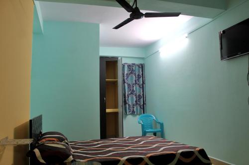 a bedroom with a bed and a ceiling fan at PG Homes in Port Blair