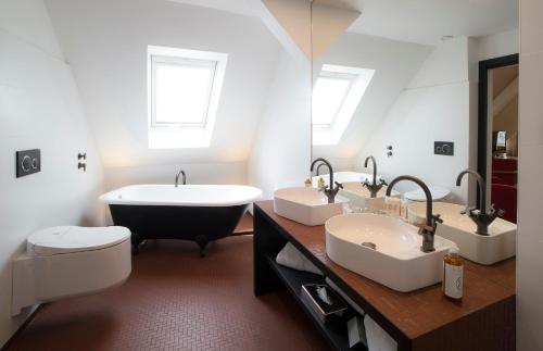 a bathroom with two sinks and a bath tub at HANNONG Hotel & Wine Bar in Strasbourg