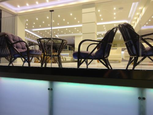 a reflection of chairs and a slide in a store window at New Aegli Resort Hotel in Poros