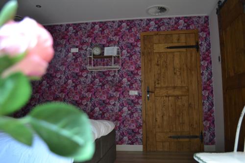 a room with a door and a floral wall at Bed & Breakfast aan de Beek in Arcen