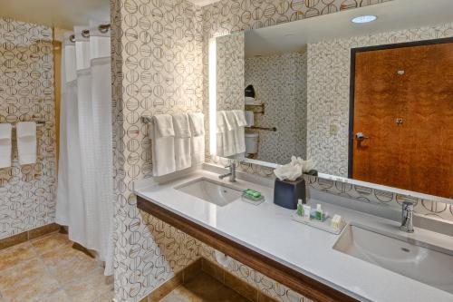 a bathroom with two sinks and a large mirror at Holiday Inn Rocky Mount I-95 @ US 64, an IHG Hotel in Rocky Mount