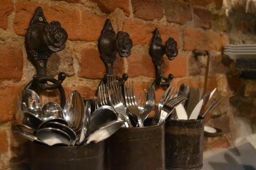 three metal containers filled with utensils on a wall at Bed & Breakfast aan de Beek in Arcen
