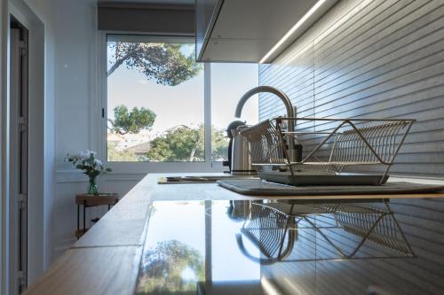 a kitchen with a basket on a counter with a window at BEACHOME4U3 in Carcavelos