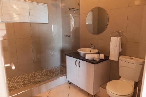 a bathroom with a shower and a toilet and a sink at 516 Umdloti Resort in Umdloti