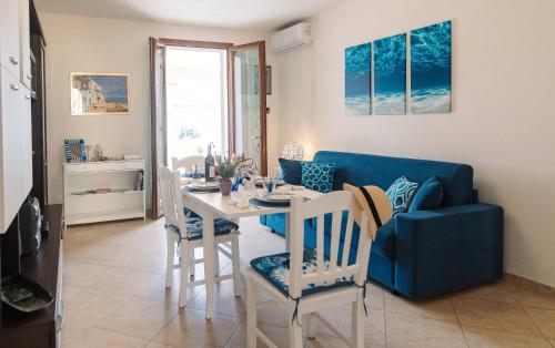 sala de estar con mesa y sofá azul en Dimora del Sole, en Torre Pali