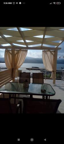 a table and chairs on a balcony with a view of the ocean at To limanaki in Finikounta