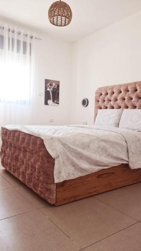 a large bed in a white room with a large mattress at דירה מפנקת מעל הכנרת in Migdal