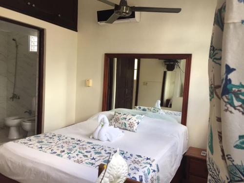 ein Schlafzimmer mit einem Bett und ein Badezimmer mit einem Spiegel in der Unterkunft The Boat House in Boca Chica
