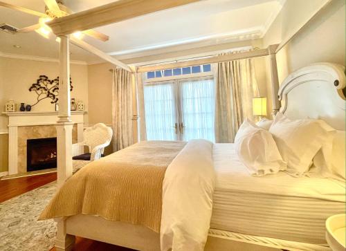 a bedroom with a large white bed and a fireplace at Inn on Main Hotel in Manasquan