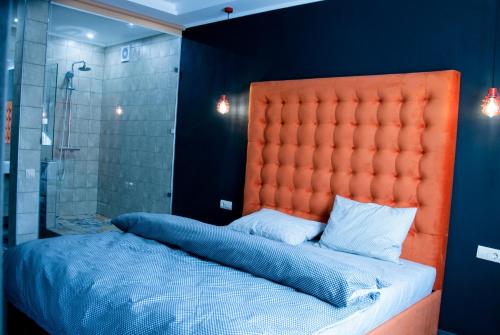 ヴィーンヌィツャにあるЭксклюзивная квартираのバスルーム(オレンジのヘッドボード付きのベッド1台付)