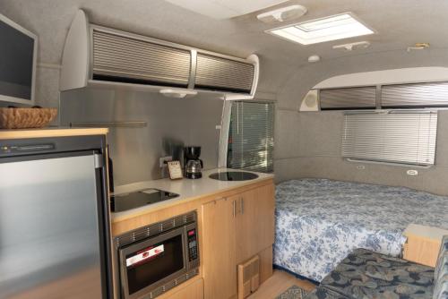 an rv kitchen with a bed and a sink at Airstream in the Center of it All in Miami