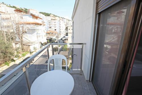 a balcony with a white table and chairs on a building at Hotel Star in Sarandë