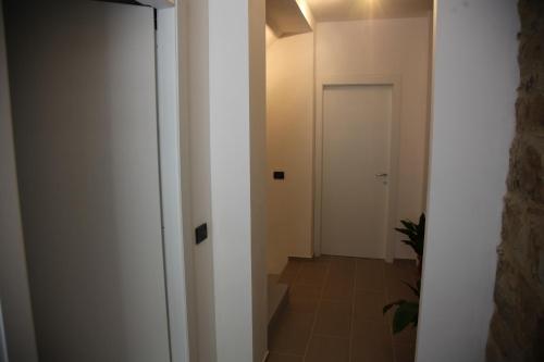 an empty hallway with a white door and a tile floor at Il Miglio in Più in Castel di Tusa