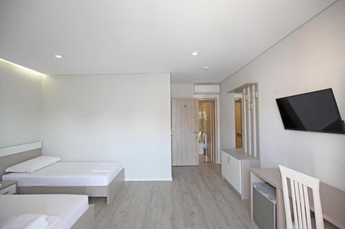 a white room with a bed and a flat screen tv at Hotel Star in Sarandë