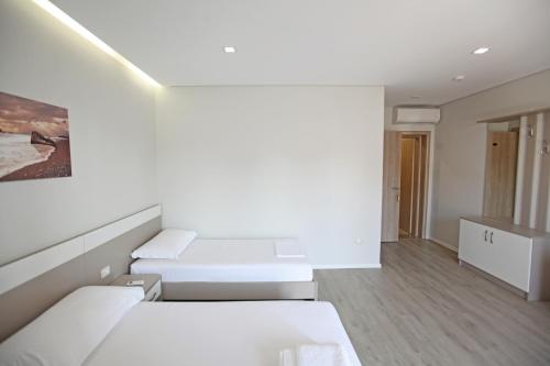a white room with two beds in it at Hotel Star in Sarandë