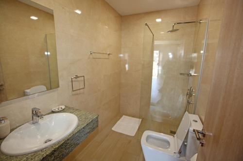 a bathroom with a sink and a shower and a toilet at Hotel Star in Sarandë