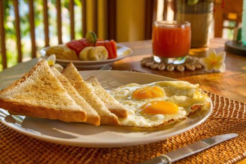 ein Teller mit Eiern und Toast auf einem Tisch in der Unterkunft Aquamarine Seaview Villa in Amed