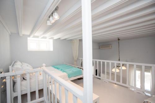 ミコノス・シティにあるTraditional Split level house in Mykonos Townの天井の客室内の白いベビーベッド
